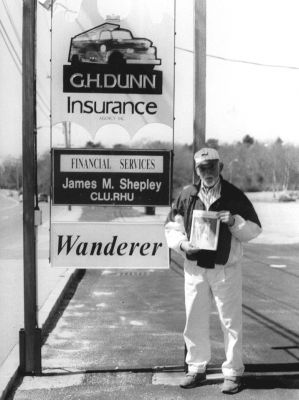 05-09-02
After a year and a half of sponsoring our Wandering Wanderers photo submission contest, Fairhavens Walter F. Tyz has to take the prize for most clever submission. Mr. Tyz sent this photo along with a note stating I got a passport and motored all the way to Mattapoisett with my copy of The Wanderer (and) posed in front of the edifice and adjacent areas of that exotic location. Yes, here he is standing in front of our office on County Road in Mattapoisett. Oddly enough, its the last place we think of in terms of ideal vacation spots, but to each his own. (Photo courtesy of Walter Tyz). 5/9/02 edition
