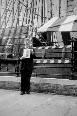 07-21-01
Jo Pannell, Mattapoisett Historical Commission member, poses with the very  first issue of The Wanderer (Volume 1, Number 1) in front of another venerated ship, The Golden Hinde, which is docked along the River Thames in England. Ms. Pannell recently took a vacation there to visit family members and brought along this landmark debut issue with her. 7/21/01 edition
