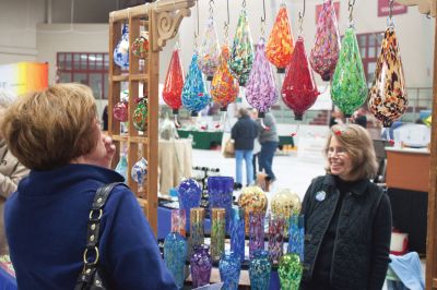 Habitat for Humanity Home and Garden Show
Jennie Elias (right), who with her husband John, run Elias Glass Studios out of Westport, speaks with a customer about hummingbird feeders. 
