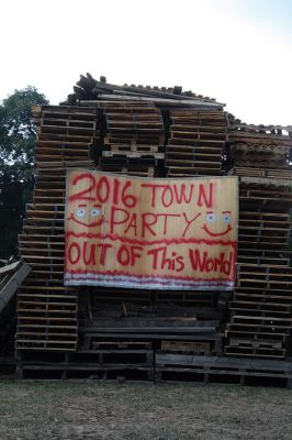 Marion Town Party 
The town collected hundreds of wood pallets and stacked them sky high in the ball field beside the Town House in anticipation of the annual Marion Town Party on Saturday, August 27. The theme of this year’s party, “Out of This World,” was appropriately represented in the playful banner hung on the stack of firewood and eventually burned along with it in an enormous bonfire. Photo by Jean Perry
