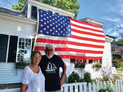 A Patriotic Promise 
Bonnie and Paul Tavares keep the tradition alive of displaying this massive flag every year as past owners of the Pleasant Street home have done before. Photo by Jonathan Comey
