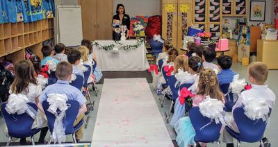  “Q” and “U” 
Deborah Bacciocchi’s kindergarten class at RMS celebrated a wedding of “Q” and “U” on May 16. The bride (a wooden letter "Q") wore a gown sewn with pieces from Bacchiocchi’s wedding gown and the groom wore mixed media/Sharpie formalwear. The gift registry yielded essentials like quarters, quilts, queens, and quartz, all elaborately wrapped by the kids. The reception followed with music, dancing, and cake. Photos by Erin Bednarczyk
