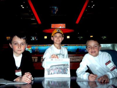 ESPN Visit
Patrick Briand, Jacob Fluegel and Hunter Parker, all of Mattapoisett, pose with a copy of The Wanderer at the ESPN Sports Center anchor desk. The boys were recently given a private tour of the ESPN studios in Bristol, CT.  (photo submitted by Sarah Briand) (April 16, 2009 edition)
