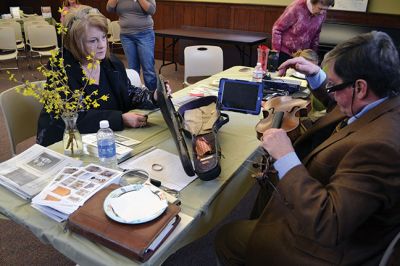 Library Treasures
Word spread of the Antiques Roadshow-style fundraiser at the Mattapoisett Library on March 29, attracting scores of South Coasters clutching their treasures, antiques, and heirlooms for appraisal and admiration, hoping Francis McNamee of the Marion Antique Shop might discover worth in their belongings beyond their sentimental value. Paying $5 per item appraised, some brought primitive dolls, old books, tea sets, and artwork. By Jean Perry
