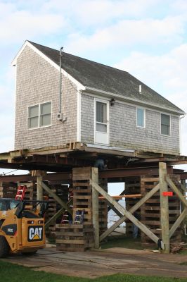 House Boat
On September 22, a construction crew continues to work on dislodging a house on Wilbers Point in Fairhaven. The house will be loaded onto a barge and floated over Buzzards Bay to its new location on Brant Beach Ave. in Mattapoisett. Since tides and winds are critical to safely moving the house, the move has been rescheduled several times. Photo by Anne OBrien-Kakley
