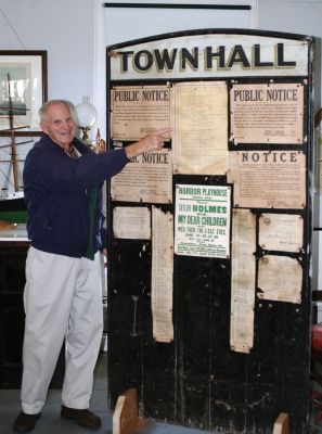 Bulletin Board Booty
Mattapoisett Historical Society President Seth Mendell points to the amusing poem scrawled on a chart of the Gulf of Maine that was tacked to a large bulletin board that was once installed near the front door of the Mattapoisett Town Hall. The bulletin board was pilfered by a group of sailors during a night of drunken mischief back in the summer of 1941 and was only recently returned to the Mattapoisett Museum and Carriage House. (Photo by Kenneth J. Souza).
