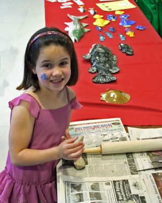 Arts in Action
Sippican School First Grader Emily Hiller tries to create the lifelike ceramic fish from Grainger Pottery on display at the recent Arts in Action program held at the school. On May 13, the Marion school hosted its first Arts in Action show for members of the staff and local artists. Among other interesting and unique displays were Russian Egg painting, bird carving, mural painting, flip-flop sandal decorating and portrait sculpture.
