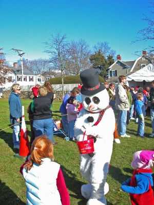 Making Merry in Mattapoisett
Frosty the Snowman hands out candy canes to eager children in Mattapoisett's Shipyard Park during the town's first annual Holiday Village Stroll on Saturday, December 2. Frosty was also joined by Santa Claus, Mrs. Claus, Rudolph the Red-Nosed Reindeer, and various helpful elves during the festivities which included music, food, fun and games. (Photo by Robert Chiarito).
