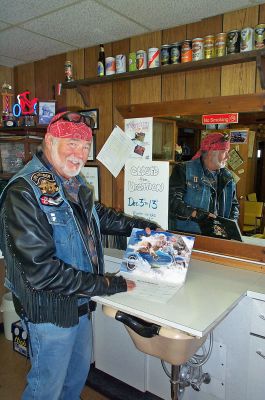 Calendar Guy
Al Hamer of Als Yankee Clipper in Marion shows off his wife, Miss November, in his latest 2006 Survivors calendar which depicts local women who are all cancer survivors either riding on or posing with classic motorcycles. The proceeds from the calendar, created by Mr. Hamer with his brother-in-law, David Blanchette, will benefit the American Cancer Society. (Photo by Kenneth J. Souza).
