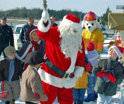 Here Comes Santa Claus!
Santa and his friends arrived by Fire Engine to greet a group of happy children during the recent Holiday in the Park celebration in Mattapoisetts Shipyard Park. (Photo courtesy of Rebecca McCullough).

