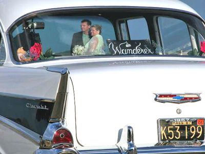 Wandering '57 Chevy
On Wednesday, August 23, 2005, Ronald and Debbie Medeiros of New Bedford (pictured through windshield) celebrated their 20th anniversary by renewing their wedding vows at Neds Point in Mattapoisett. The couple was taken to the ceremony in this classic 57 Chevy, which just so happens to be called The Wanderer and is owned by Jacqueline Sylvia, also of New Bedford. (Photo by and courtesy of Anita Silva).
