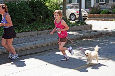 Marion Village 5K
A young runner in the tenth annual Marion Village 5K Road Race takes along a jogging companion to keep her company as she heads toward the finish line. (Photo by Robert Chiarito).
