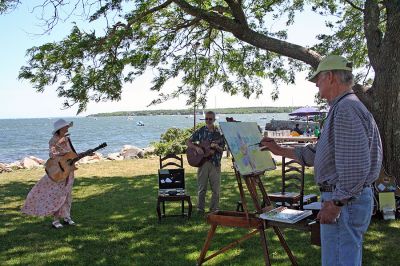 Arts in the Park
Marion artist Charles Parsons paints a portrait while Mattapoisett Library Director and musician Judy Wallace and her husband David Gries perform during the recent "Arts in the Park" benefit to raise money for furnishings in the new Mattapoisett Public Library which was held on Sunday, June 24 in Shipyard Park in Mattapoisett. (Photo by Robert Chiarito).
