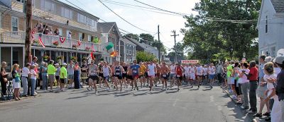 2007 Mattapoisett July 4 Road Race
A record-setting 988 runners registered for this year's 37th annual Mattapoisett July 4 Road Race with an estimated 922 ultimately crossing the finish line in the five-mile event. Here runners can be seen charging down Water Street from Shipyard Park just seconds after the starting gun. (Photo by Kenneth J. Souza).

