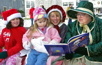 A Christmas Story
Three-year-old Emily Wilson of Marion enjoys a Christmas story read by Elaine Botelho (center) and Bobbie Gaspar at Mattapoisetts Holiday in the Park. Alison Feltman, far left, handed out candy canes during festivities as Santa made his annual arrival and local musicians filled the frosty air with Christmas carols. (Photo by Laura McLean).
