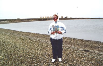 Fuel for Trip
Nancy Kubik of Mattapoisett poses with a copy of The Wanderer on the west dock of the British Petroleum Oil Field at Prudhoe, Bay, Arkansas, during a recent trip.

