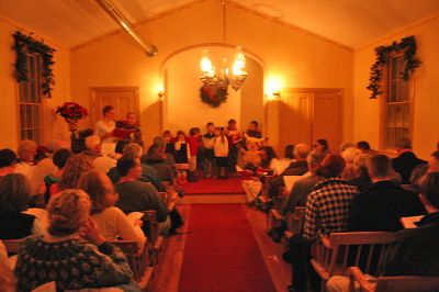 Chapel Caroling
Holiday caroling was held at the Tinkhamtown Chapel in Mattapoisett on Saturday, December 20. The annual Christmas tradition included a sing-along celebration of holiday music. The chapel, quaintly lit by oil lamps and heated by a pot-belly stove, provided the perfect old-fashioned setting. (Photo by Robert Chiarito).
