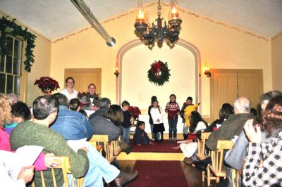 Chapel Caroling
Holiday caroling was held at the Tinkhamtown Chapel in Mattapoisett on Saturday, December 20. The annual Christmas tradition included a sing-along celebration of holiday music. The chapel, quaintly lit by oil lamps and heated by a pot-belly stove, provided the perfect old-fashioned setting. (Photo by Robert Chiarito).
