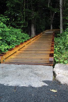 Osprey Marsh Accessible Boardwalk
Despite a downpour perfectly timed for its planned gathering on Friday off Point Road in Marion, the Sippican Lands Trust celebrated the completion of the new Osprey Marsh Accessible Boardwalk. Executive Director Jim Bride and president Alan Harris held a live Zoom meeting for those who could not attend, and some of the donors for the project assisted in the ribbon-cutting. The boardwalk is open by appointment. See story by Marilou Newell. Photo by Mick Colageo
