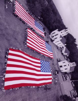 Old Glory
Photographs from the Rochester Country Fairs unfurling of the American Flags with the National Flag Truck are now available for purchase. The Rochester Country Fair hired Rochester resident Robert Manny of Through the Lens Photography to capture these memorable town photos taken from above, in bucket trucks donated by Barnes Tree Service and Beacon Rentals. Several different photos are available to choose from ... stop by Bev Loves Books located in the Plumb Corner Mall to see them for yourself.
