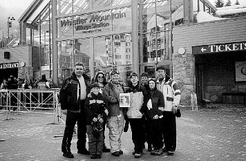 03-22-01-2
The LePage and Towers families of Rochester recently headed for cooler climes during February vacation when they visited Whistler Mountain in British Columbia, Canada and took along a piece of home with them in the form of their favorite weekly, The Wanderer, which they posed with here outside the ski resorts Village Station at elevation 677 m. Pictured here are (l. to r.) Bill, Linda, Mary-Elizabeth, and Dan Towers; and Brad, Tina, Christopher, and Tara LePage, all of Rochester. 3/22/01 edition
