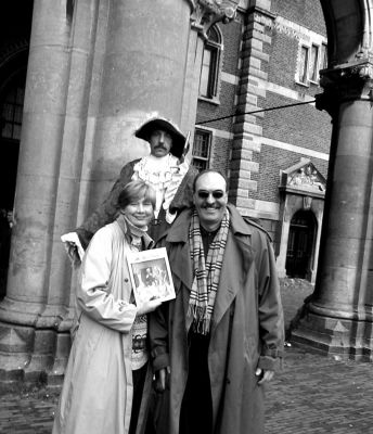 02-14-02-1
This photo was taken on a recent trip to Amsterdam, The Netherlands. Outside the Rijksmuseum, standing behind Fransje and Nick Zucchero from Pine Island Road in Mattapoisett is a living statue of a seventeenth century gentleman, most likely a member of a military company. This period-bedecked man might have been an ideal subject for one of Rembrandts paintings.  2/14/02 edition
