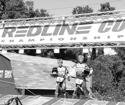 091803
Robert and Daniel Goodman Jr. pose with a copy of The Wanderer after Robert won the Redline Cup Championship in his class of 12-year-old Intermediates recently, beating out 25 other riders in his class. Daniel struggled all weekend at the bike competition but did not qualify for the main event in his class. (Photo by and courtesy of Dan Goodman). 9/18/03 edition
