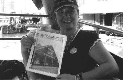 122304-3
Former Mattapoisett native and current Los Angeles resident Toya Doran Gabeler recently took a trip to Hong Kong and posed with a copy of The Wanderer here in Aberdeen Harbor, a unique community of rag-tag looking boats where families reside full-time on the water. 12/23/04 edtion
