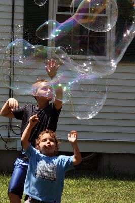 Keeping it cool
Kids gathered outside the Joseph H. Plumb Memorial Library on Friday, July 21, chilling in the shade drenched in bubble stuff with Vinny the Bubble Guy. Photos by Jean Perry
