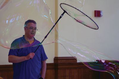 Bubbles, bubbles, everywhere! 
Kids were spellbound by Keith Johnson and his “Bubbleology” show at the Marion Music Hall on June 22, sponsored by the Elizabeth Taber Library. Ty Mackenzie, 9, was the lucky one who got to be swallowed up by a giant bubble. Photos by Jean Perry
