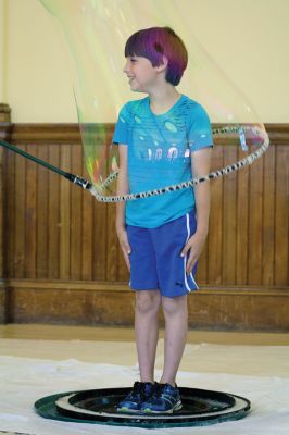 Bubbles, bubbles, everywhere! 
Kids were spellbound by Keith Johnson and his “Bubbleology” show at the Marion Music Hall on June 22, sponsored by the Elizabeth Taber Library. Ty Mackenzie, 9, was the lucky one who got to be swallowed up by a giant bubble. Photos by Jean Perry
