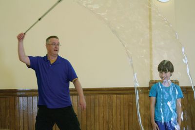 Bubbles, bubbles, everywhere! 
Kids were spellbound by Keith Johnson and his “Bubbleology” show at the Marion Music Hall on June 22, sponsored by the Elizabeth Taber Library. Ty Mackenzie, 9, was the lucky one who got to be swallowed up by a giant bubble. Photos by Jean Perry
