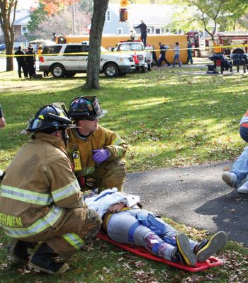 Worst Case Scenario
Fairhaven Fire Department hosted a full-scale exercise to improve emergency response in the region. Mattapoisett, Rochester, Dartmouth, Freetown, Acushnet, and New Bedford all responded to a disaster that simulated an accident between a school bus and an oil truck at Livesey Park in Fairhaven. Twenty drama students from New Bedford Vocational High School played the part of injured students who were assessed and treated for injuries. Photo by Anne OBrien-Kakley.
