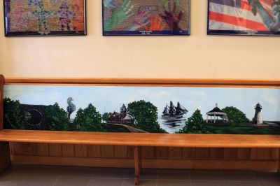 Center School Donation
An antique church pew gifted to Center School by James and Roxanne Bungert features a painted depiction of landmarks throughout Mattapoisett, including the school. Photo by Marilou Newell
