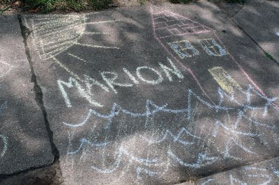 Chalk It Up
The day before the Marion Town Party, kids chalked-up the sidewalks in front of the Marion Town House in preparation for the Saturday night event. Town Party Planning Committee members set up picnic tables and strung party lights in the background while the kids drew colorful, festive pictures with chalk. Photos by Jean Perry
