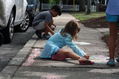 Chalk It Up
The day before the Marion Town Party, kids chalked-up the sidewalks in front of the Marion Town House in preparation for the Saturday night event. Town Party Planning Committee members set up picnic tables and strung party lights in the background while the kids drew colorful, festive pictures with chalk. Photos by Jean Perry
