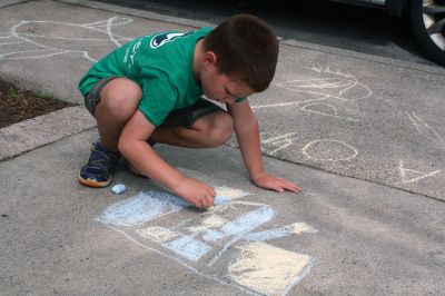 Chalk It Up
The day before the Marion Town Party, kids chalked-up the sidewalks in front of the Marion Town House in preparation for the Saturday night event. Town Party Planning Committee members set up picnic tables and strung party lights in the background while the kids drew colorful, festive pictures with chalk. Photos by Jean Perry
