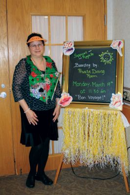 Sippican Royale
Activities Director, Anne O’Connell Bishop stands near the grass skirted menu at the dining room at Sippican Healthcare Center’s cruise ship. Photo by Joan Hartnett-Barry
