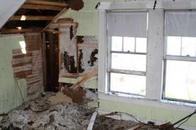 Historic Fire
The insulation, seen here spilling out into an upstairs room, helped limit the amount of damage the houses roof sustained. The exposed lathe and roof revealed hand-hewn beams that Mr. Dexter hopes to keep exposed in the houses renovation.
