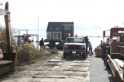 Hitting the Beach
A 25-ton house, gifted from Rochester resident Greg Kamon to soon-to-be Mattapoisett resident Deborah Francoeur, sits on a barge at the end of Brant Beach on November 5, 2009 while workers from New England Harbor Services and Mike Reid Mover Builders wait for 1:00 pm low tide to unload the house. Photo by Paul Lopes
