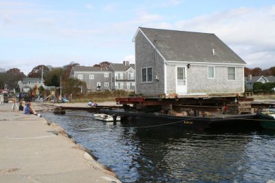 Hitting the Beach
A 25-ton house, gifted from Rochester resident Greg Kamon to soon-to-be Mattapoisett resident Deborah Francoeur, sits on a barge at the end of Brant Beach on November 5, 2009 while workers from New England Harbor Services and Mike Reid Mover Builders wait for 1:00 pm low tide to unload the house. Photo by Paul Lopes
