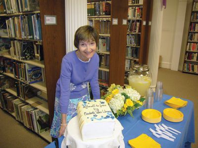 Judy Kleven Retires
Scores of admirers gathered on Friday to celebrate the service of Head Librarian Judy Kleven, who retired after 27 years at Elizabeth Taber. Young Max Richins presented Kleven with an Eiffel Tower-themed card, as she hopes to travel to Paris in retirement, while others brought a book-shaped cake and a new cat – Noah. Photos by Joan Hartnett-Barry
