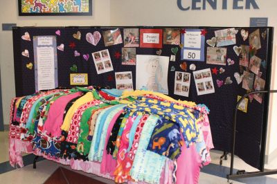 Project Linus
Fifteen students from Jane Tougas' eighth grade Enrichment Class display the 50 blankets they helped make for Project Linus, a charity that provides handmade blankets to seriously ill and traumatized children. Front row, left to right: Olivia Lanagan, Lizzie Machado, Seth Richard, and Chris Demers. Back row, left to right: Renae Reints, Tori Saltmarsh, Katie Zartman, Kelly Kay, Ali Grace, Nicholas Bergstein, and Andrew Dessert. Photo by Anne O'Brien-Kakley.
