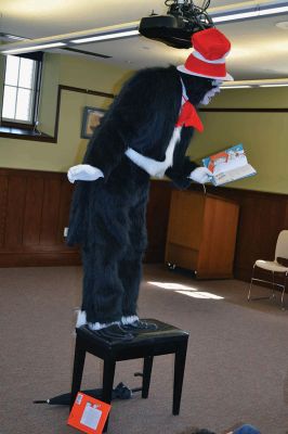 Mattapoisett Free Library Birthday
“Say Triskaidekaphobia!” the Cat in the Hat told the children, posing for a photo at the Mattapoisett Free Library on Saturday, March 22. What the heck is that, the children asked the Cat in the Hat. “Google it!” he told the children laughing at his silliness. The library knows how to throw a party, celebrating five years since the Friends of the Mattapoisett Library funded the expansion of the library. “They even bought a cake,” said Children’s Services Librarian Sandra Burke.  By Jean Perry
