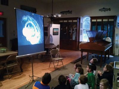 Marion Natural History Museum
Dr. Michael Moore of Woods Hole Oceanographic Institute, using the museum's harpoon and baleen, introduced the Marion Natural History Museum's after-school group to a little of Marion's whaling history. Students could ask questions and theorize why Sippican Harbor had the first recorded visit from a humpback whale this fall. We wish to thank Dr. Moore for the great program. Photo courtesy Elizabeth Leidhold
