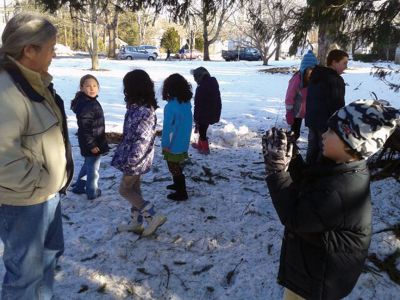 Marion Natural History Museum 
The Marion Natural History Museum afterschool group explored how different species of animals survive the winter. Naturalist Sarah Porter shows the students examples of lichens and mosses on which herbivores might snack if no leaves are available. Photo courtesy of Elizabeth Leidhold
