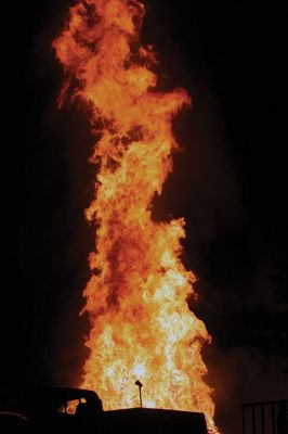 Marion Town Party 
The town collected hundreds of wood pallets and stacked them sky high in the ball field beside the Town House in anticipation of the annual Marion Town Party on Saturday, August 27. The theme of this year’s party, “Out of This World,” was appropriately represented in the playful banner hung on the stack of firewood and eventually burned along with it in an enormous bonfire. Photo by Jean Perry
