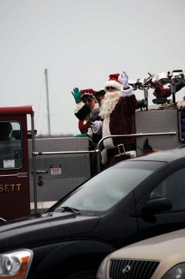 Santa Arrives
Mattapoisett held its annual holiday celebration and tree lighting on Saturday, December 5, 2009 at Shipyard Park. The rain couldn't dampen holiday spirits as visitors enjoyed delicious food and listened to Christmas music performed by the Showstoppers. Children made their own ornaments and hung them on the Christmas tree. They also danced with Rudolph and Frosty and shared their Christmas wishes with Santa Claus. Photo by Felix Perez.
