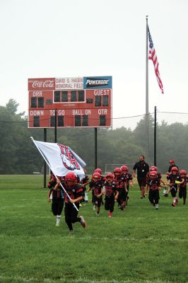 Old Rochester Youth Football
 Robert Randall III carries the “OR” flag, leading the Old Rochester Youth Football 8-and-under squad onto Hagen Field for its game against Dighton-Rehoboth on Sunday morning. The ORYF Bulldogs football teams and cheerleaders brightened up a dreary day with spirited performances against rugged D-R squads. Photo by Mick Colageo
