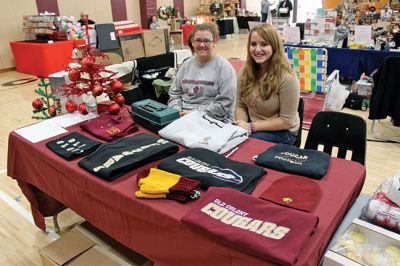 Old Colony Craft Fair
Students, faculty, and vendors packed the Old Colony Regional Vocational Technical High School Craft Fair on Saturday, part of the school’s homecoming festivities. Pictured here are Taylor Raposa (left) and Amy Pringle selling OC-themed clothing and merchandise, as well as Jim Silva, a member of the Gateway Wood Turners. Collin Staledo displayed his welded turkey, while Duncan and Ruth Rynne showcased their “Redneck Wine Glasses.” Even the OC Cougar made an appearance. Photo by Nick Walecka.
